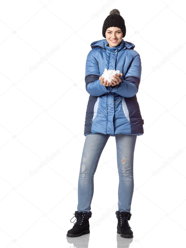 Portrait of a young girl with a smile in winter clothes with sno