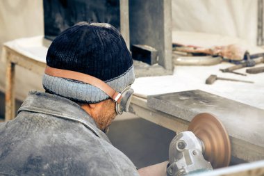 İşçi granit taş bir öğütücü ile işler.. 