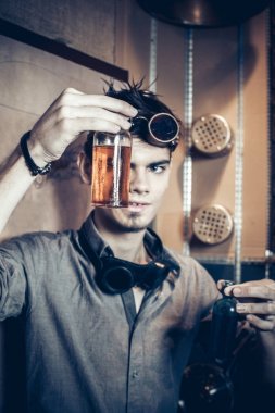 Genç bir deli bilim adamı portresi steampunk tarzı giyinmiş ve