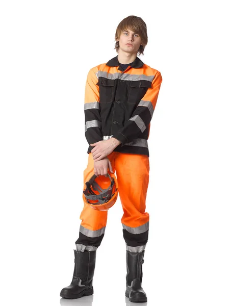 Junger gutaussehender Bauarbeiter in orangefarbener Uniform mit Helm in der Hand. — Stockfoto