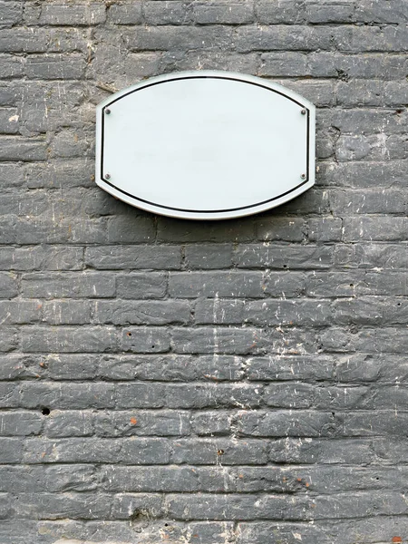 Placa oval branca na fachada de uma parede de tijolo . — Fotografia de Stock
