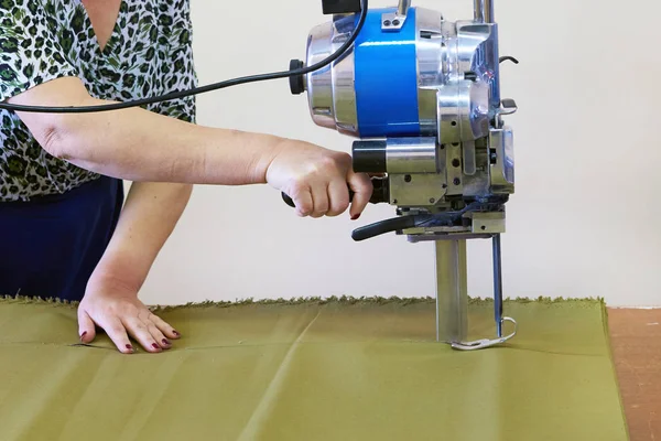 Швачка жінка працює на промисловій машині для різання тканини — стокове фото
