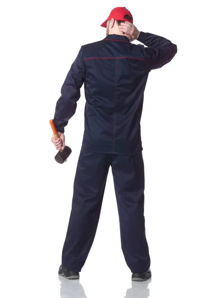 Rear view of a young repairman, wearing a red cap with a hammer. — Stock Photo, Image