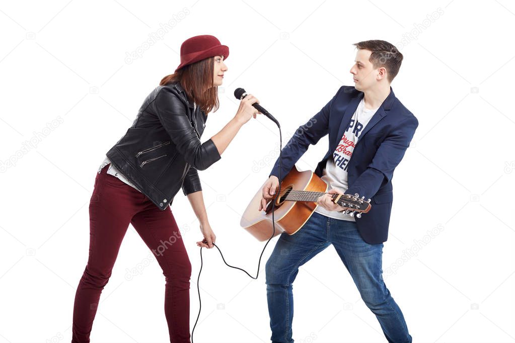 A musical duo of a young couple, a singer in a red hat with a mi