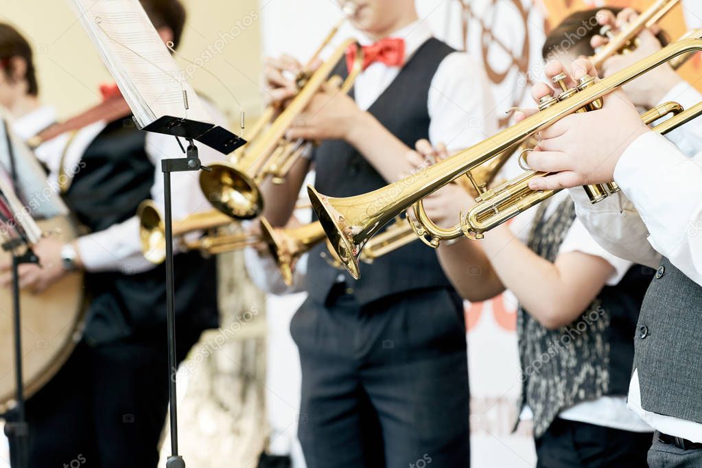 Closeup of a group of children playing musical instruments.