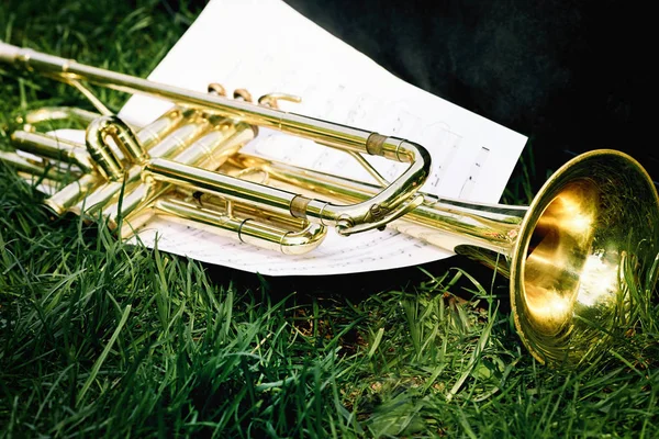 Primer plano de una trompeta y hoja de música con notas . — Foto de Stock