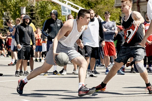 A group of young guys playing street basketball in the city squa — Stock Photo, Image