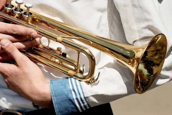 Genç bir adam bir trompet müzik aleti tutar. — Stok fotoğraf