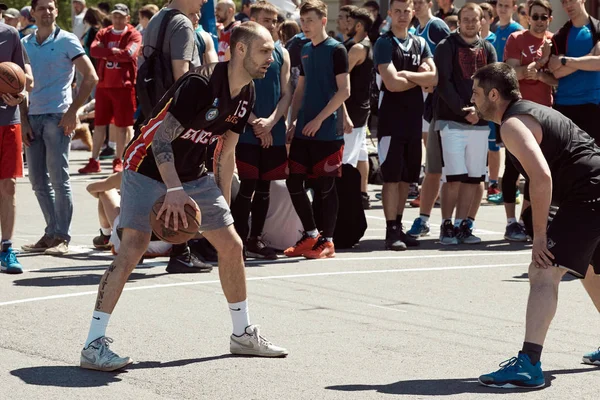 A group of young guys playing street basketball in the city squa — Stock Photo, Image