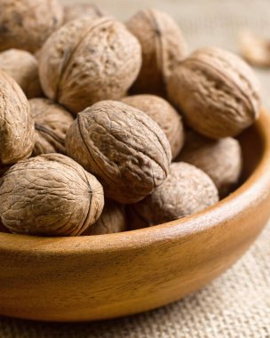 Ahşap bir tabakta dikey yakın plan fındıklar..