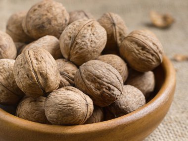 Kapalı fındıklar ahşap bir tabakta, masa arkasında, kırsal bir tarzda..