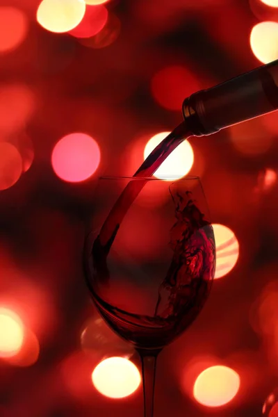 Un chorrito de vino vertido en una copa en el fondo con un gl — Foto de Stock