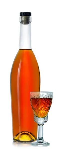 Closed bottle of cognac with a glass — Stock Photo, Image