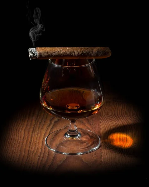 En rökig aromatisk cigarr och ett glas konjak — Stockfoto