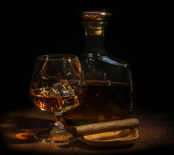 A glass of whiskey with ice, a bottle of whiskey, a cigar — Stock Photo, Image