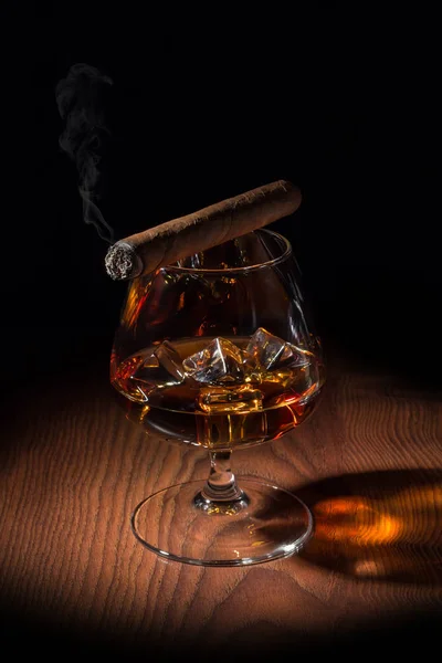 Rökt cigarr på ett glas konjak — Stockfoto