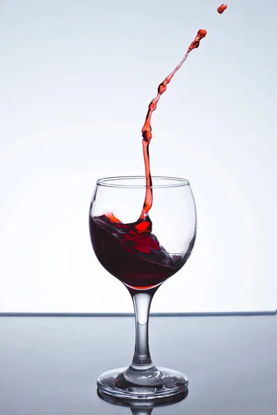 Movendo copo de vinho tinto sobre um fundo branco — Fotografia de Stock