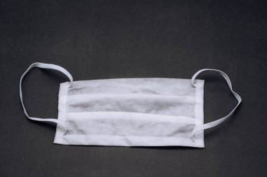Siyah arka planda beyaz tıbbi maske