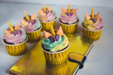 Sarı fincanda gökkuşağı unicorn keki. Halkla ilişkiler için bir ziyafet.