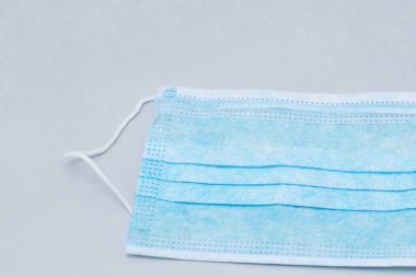 Gri arka planda mavi tıbbi maske