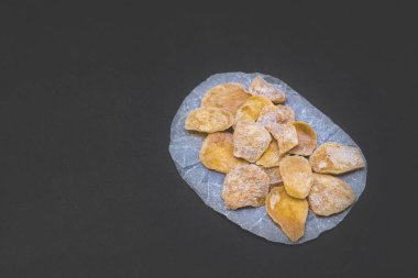 Siyah arka planda dilimlenmiş zencefil şekeri. Vejetaryen tatlıları. Detokslu tatlı.