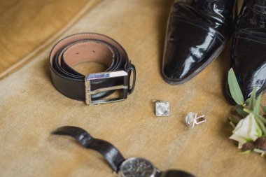 Düğün detayları. Damat aksesuarları. Ayakkabı, kol düğmeleri, kemer, izlemek, yaka çiçeği