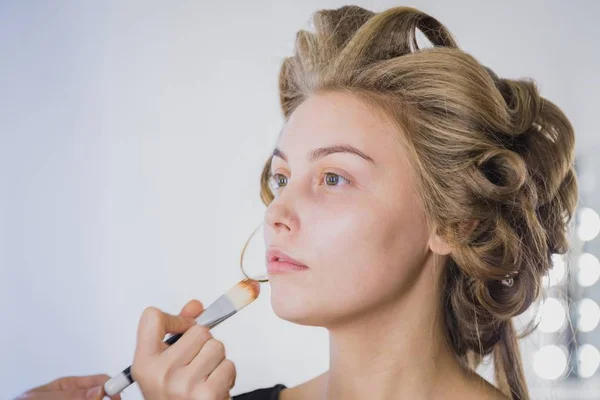 Maquiagem artista aplicando base tonal líquida no rosto da mulher — Fotografia de Stock
