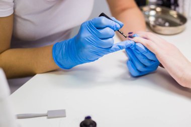 Kadın tırnak tırnak cilası uygulayarak profesyonel güzellik uzmanı