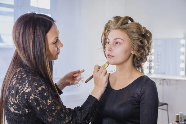 Artista de maquillaje aplicando base tonal líquida en la cara de th —  Fotos de Stock