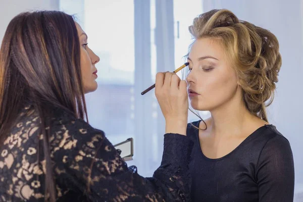 Nahaufnahme. Professionelle Visagistin trägt Lidschatten auf — Stockfoto