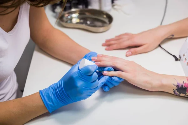 Professionele schoonheidsspecialist nagellak op vrouwelijke nagel toe te passen — Stockfoto