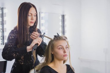 Güzel genç kadın saçlarını güzellik salonunda doğruldu oluyor