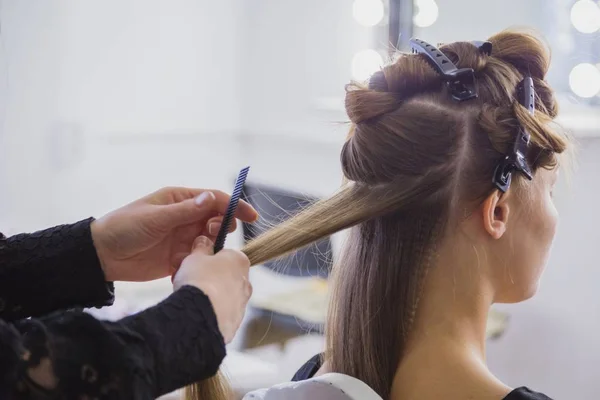 Cabeleireiro profissional fazendo penteado para jovem mulher bonita com cabelo longo — Fotografia de Stock
