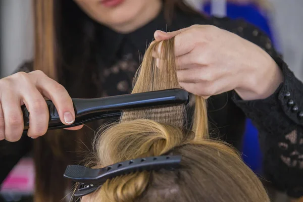 Primer plano de manos de estilista con plancha alisar el pelo de la mujer —  Fotos de Stock