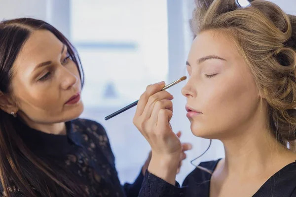 Primer plano. Maquillador profesional aplicando sombra de ojos — Foto de Stock