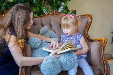 Evdeki komik küçük kız ve annesinin portresi.