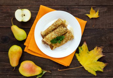 Beyaz bir tabak ta karamelize armut ile kokulu tatlı krep. Üst görünüm
