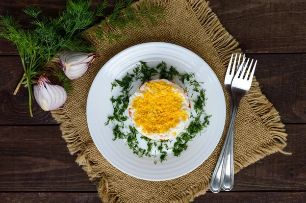 Легкий салат в форме круга (тунец в масле, вареный картофель, морковь, яйца). Альтернативное славянское традиционное блюдо "Мимоза". Вид сверху — стоковое фото