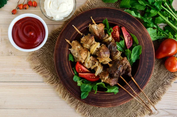 Bitar av kött med lök på spett (kebab). Servera med sås — Stockfoto