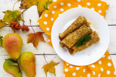 Beyaz bir tabak ta karamelize armut ile kokulu tatlı krep. Üst görünüm