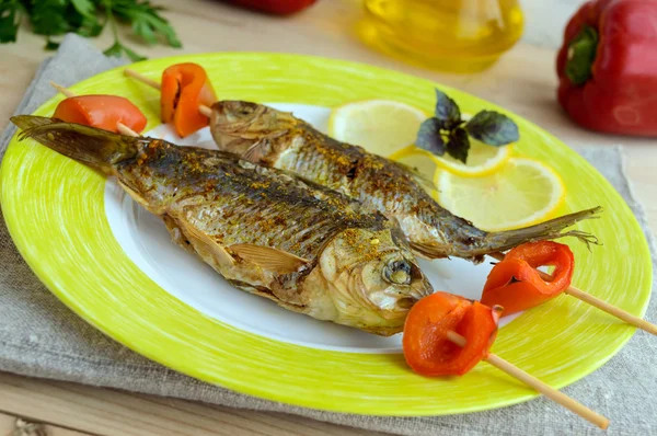 Gebakken vis (carp) op spiesen met stukjes peper en citroen. — Stockfoto