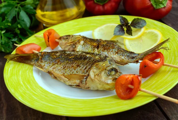 Fried fish (carp) on skewers with pieces pepper and lemon. — Stock Photo, Image