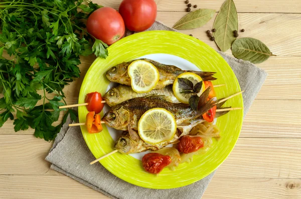 Pescado frito (carpa) en pinchos con trozos de pimiento, tomates secados al sol y limón. La vista superior — Foto de Stock