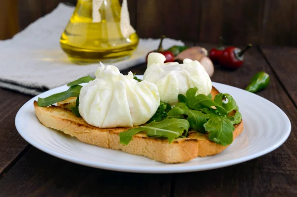 Uova sode in un sacchetto (in camicia) su pane tostato croccante e foglie di rucola verde. Colazione dietetica . — Foto Stock