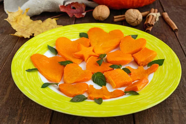 Honey Baked slices of pumpkin in the form of various figures, decorating mint leaves. Lovely snacks for a party (Halloween). Children's menu. — Stock Photo, Image