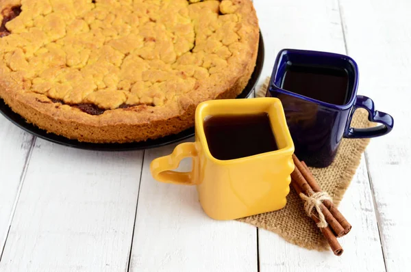 Deux belles tasses (bleu foncé et jaune) avec café, thé et gâteau maison fraîchement cuit avec confiture d'abricot . — Photo