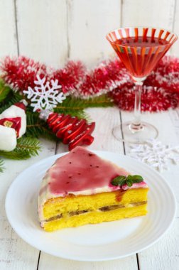 Sünger kek muz bir tabaka ile krem ve kızılcık şurubu beyaz zemin üzerine süt. Tatil tatlı. Noel Tema.