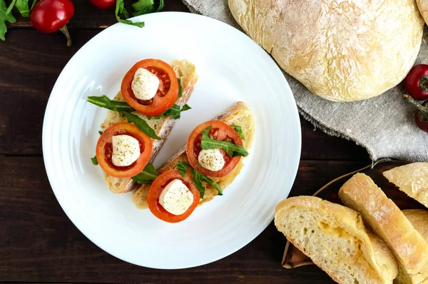 Bruschetta con rucola, pomodoro, mozzarella, olio d'oliva su fette di chiabatta. Colazione leggera. La vista dall'alto — Foto Stock