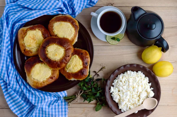 Vanília túró zsemle (cheesecake) csésze tea citrommal. Szemközti nézet. — Stock Fotó