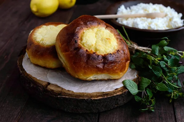 Vanille-Hüttenkäsebrötchen (Käsekuchen) auf dunklem Holzgrund. — Stockfoto